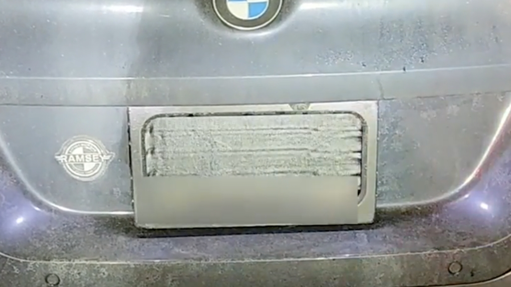 License plate cover used by a BMW driver after getting caught for owing more than $20k in toll fees